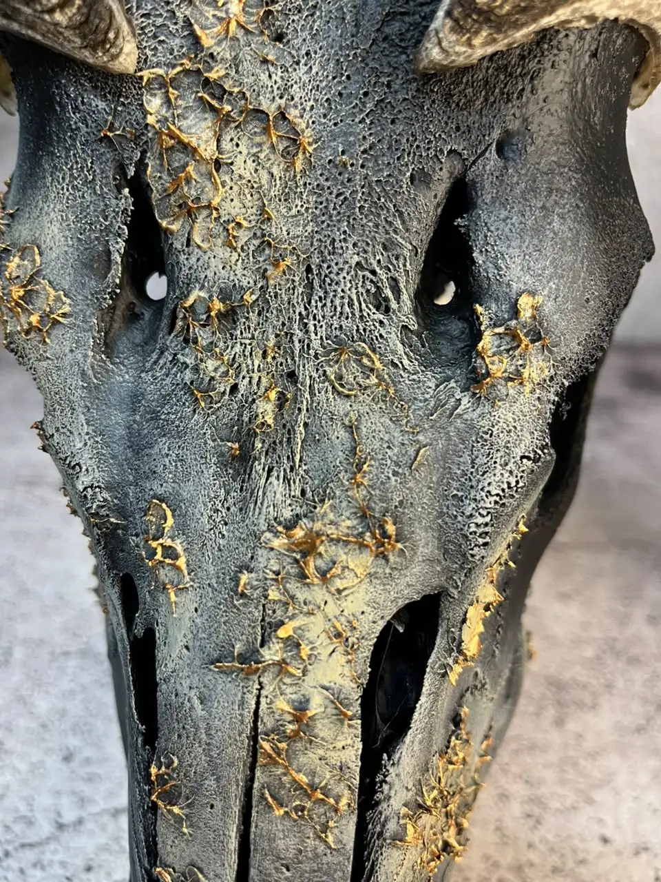Antelope skull painted deep green with gold-leaf detail and ridged black horns